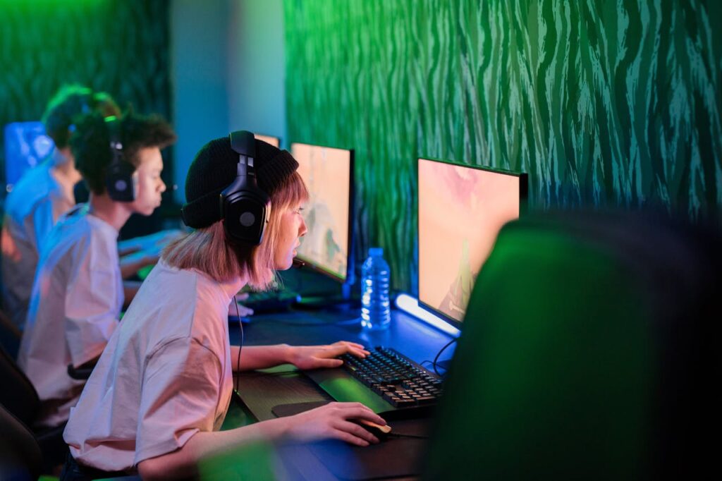 pexels photo 7849510 Gamers intensely focused on playing in a vibrant cybercafe environment.